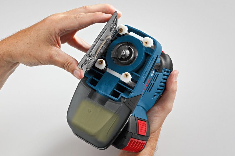 A person opens the base plate of a blue handheld power tool.