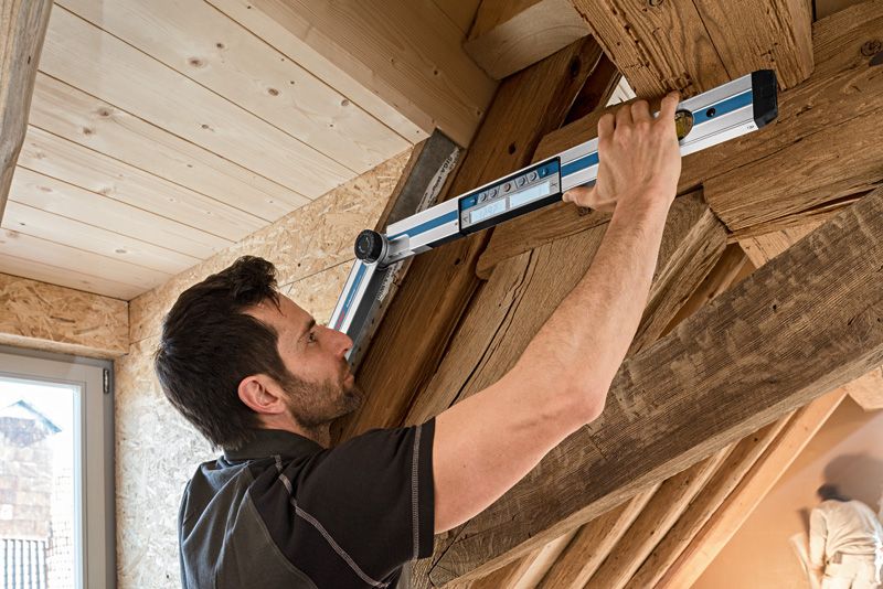 一個人用角度計測量木樑之間的角度。