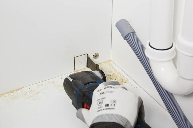 HCS 鉸鏈式切削鋸片 AIZ 32 EPC 木材 工人配戴安全設備,用電動工具在櫃子上切出一個方形開口。.