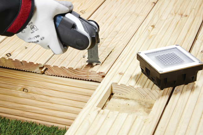 HCS 鉸鏈式切削鋸片 AIZ 32 EPC 木材 工人配戴安全設備,使用多功能工具在木質甲板上切割出凹槽。.