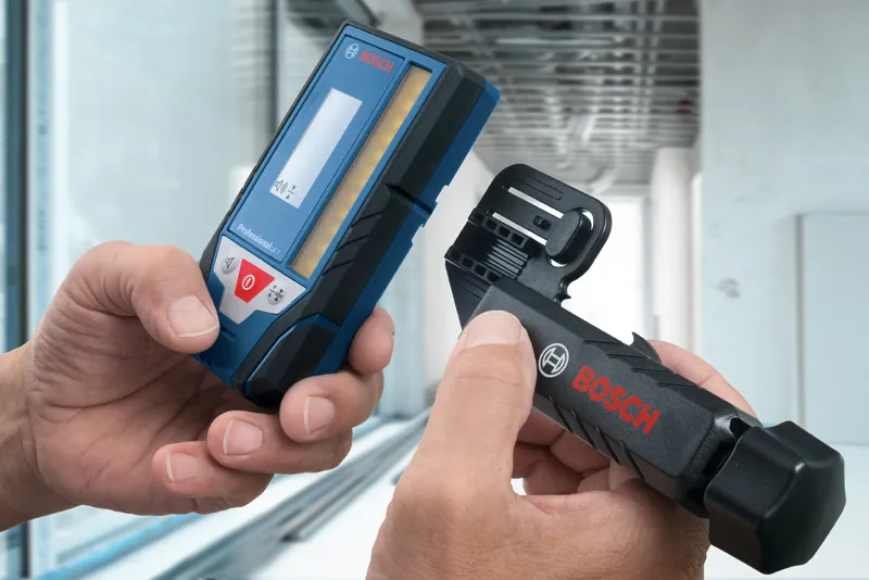 在現代室內環境中，手持雷射接收器和安裝支架的人。