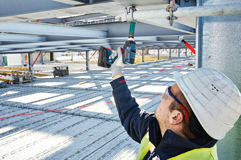 ProCORE18V 4.0Ah 一名配戴安全設備的人員使用無線衝擊扳手來擰動金屬梁。.