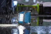 施工現場大雨期間，工作燈在濕地板上運作。.
