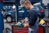 一名穿戴安全裝備的人員正在汽車修理廠的工具車上檢查熱成像儀。