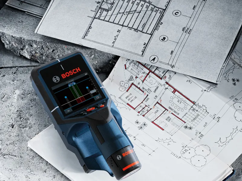 Digital wall scanner detector placed on top of architectural blueprints.
