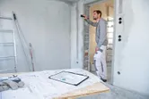 一名工人使用雷射測量儀檢查建築工地的牆壁距離。.