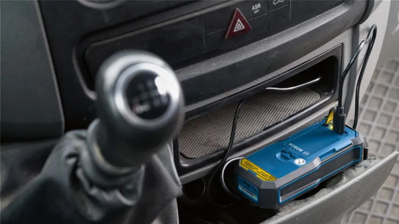電池組透過 USB 連接線在汽車控制台上充電。.