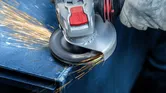 配戴安全設備的人研磨金屬，產生火花。
