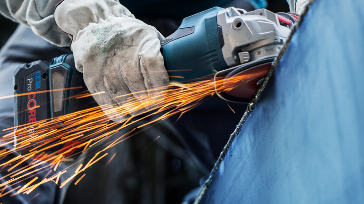 Object #200360616: 2793250_app_web_04 一名佩戴安全設備的人研磨金屬,產生明亮的火花。