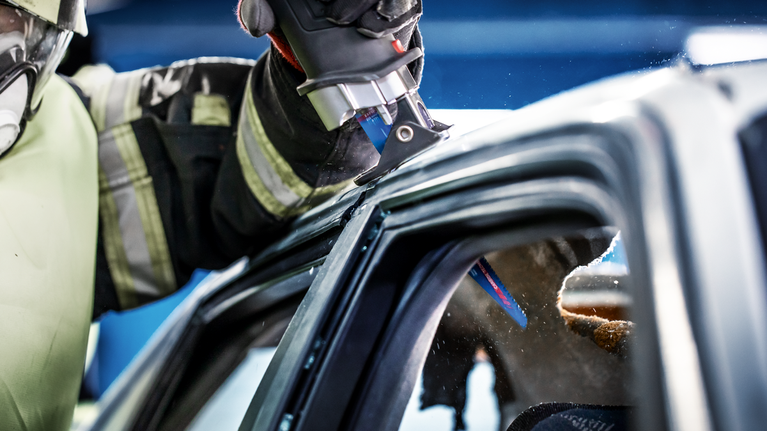 EXPERT ‘Vehicle Rescue’ S 1157 CHM 軍刀鋸 1 件式 一名配戴安全設備的人使用往復鋸切割汽車車頂。