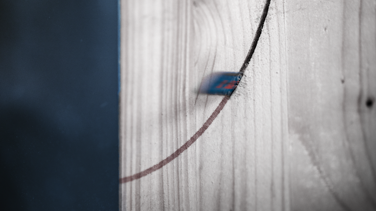 曲線鋸刀片在木板上切割出一條曲線。