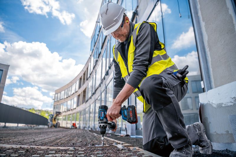 GSR 18V-150 C 一名配戴安全設備的人員在施工現場使用無線電鑽。.