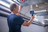 Person using an inspection camera to examine inside an overhead duct.