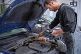 一名工作人員在車間使用檢查攝影機檢查汽車引擎。