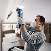 Bosch 18V-28 多功能工具用於天花板切割。