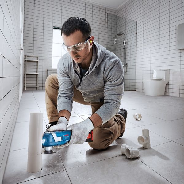 Bosch 185 多功能工具切割 PVC 管材。