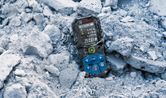 Laser measure lying on rubble at a construction site.
