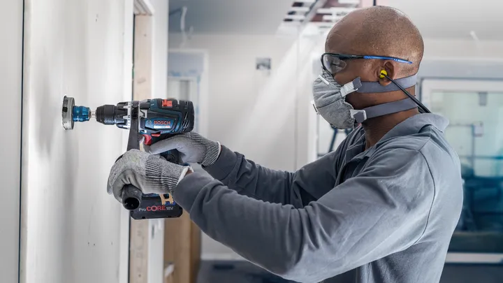 配戴安全設備的人員在內牆上鑽一個圓孔。