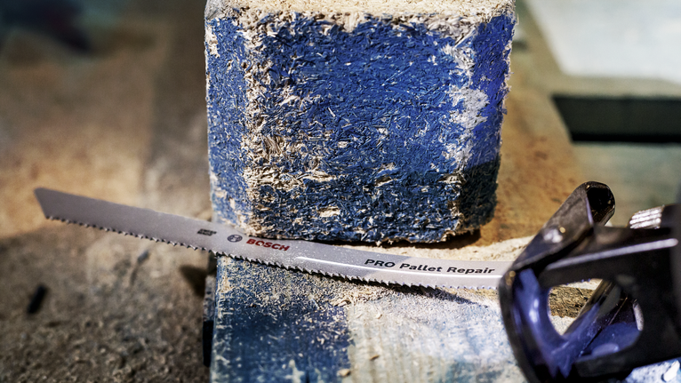 往復鋸片放置在佈滿灰塵的木質托盤塊上。