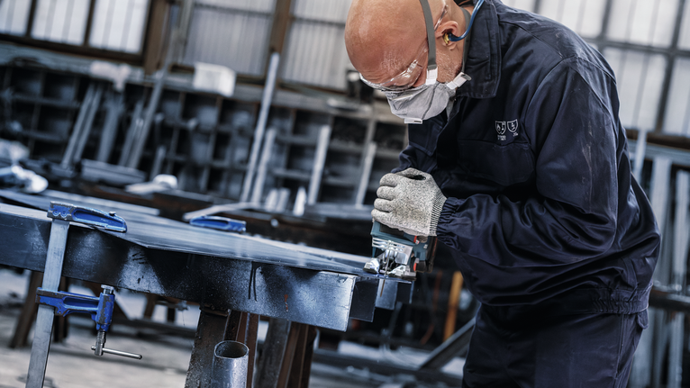 PRO Metal thick and thin T123XF 線鋸片,100 mm,5 件 配戴安全設備的人員在車間使用電鋸切割金屬。