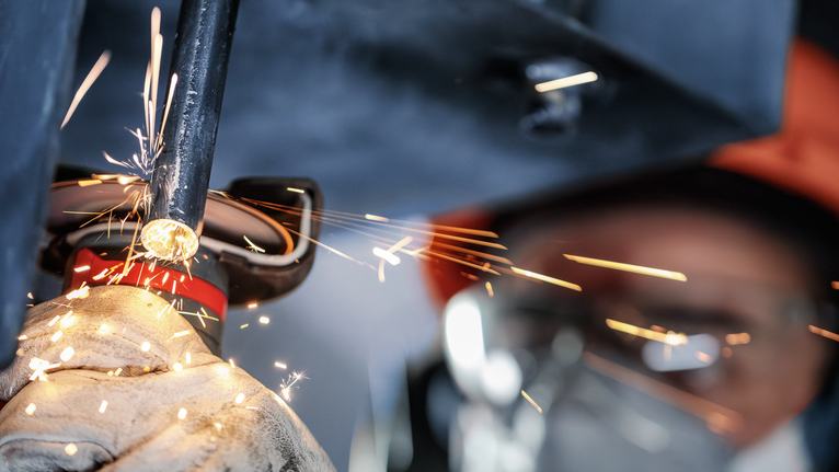 PRO Stainless Steel and Metal 接合切削砂輪片,76 x 1 x 10 mm 配戴安全設備的人員研磨金屬管,產生明亮的火花。