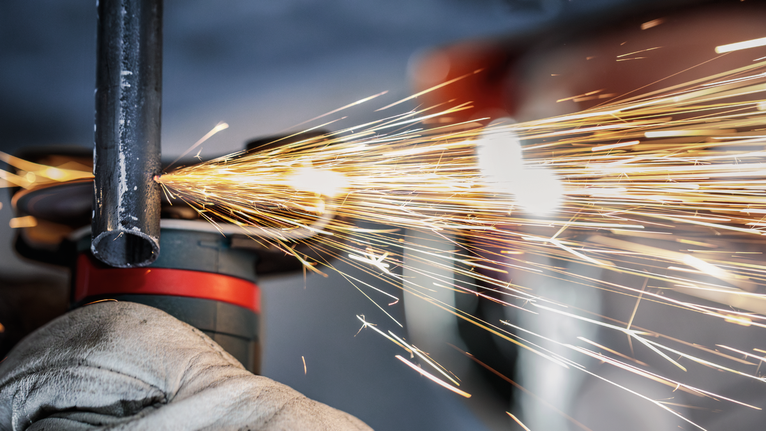 PRO Stainless Steel and Metal 接合切削砂輪片,76 x 1 x 10 mm 配戴安全設備的人員研磨金屬管,產生明亮的火花。