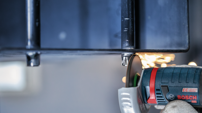 配戴安全設備的人研磨金屬，產生火花。