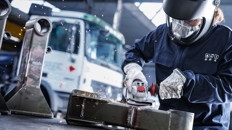 配戴安全設備的人研磨金屬，產生火花。