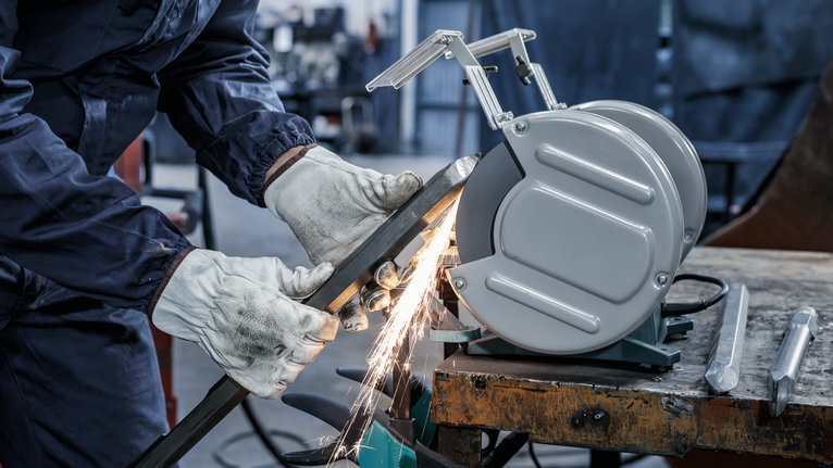 PRO Metal 研磨輪,200 x 25 x 32 mm,G36 一名配戴安全設備的人在工作台上研磨金屬,產生火花。