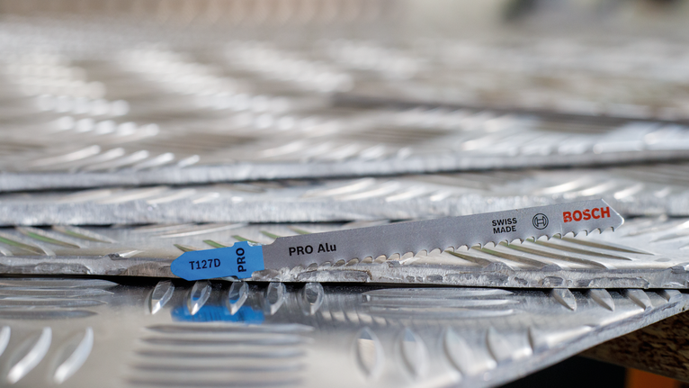 鋸片放置在堆疊的紋理金屬板上。