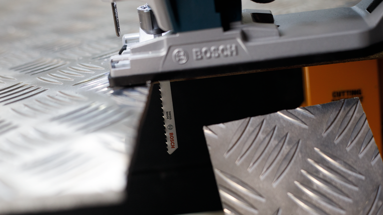 拼圖鋸切割金屬花紋板。