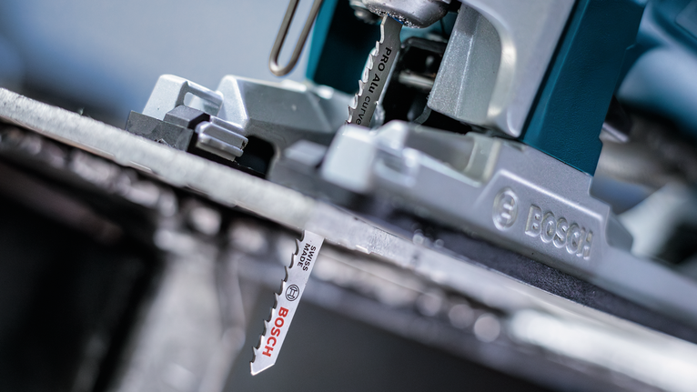 PRO Alu curve T227D 專業鋁材曲線切割款線鋸片,100 mm,5 件組 拼圖鋸刀片切割金屬板的特寫。