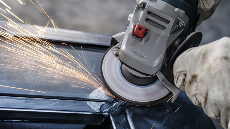 配戴安全設備的人研磨金屬，產生火花。