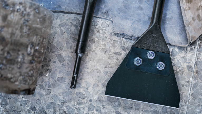 PRO SDS plus 刮剝刀,130 x 290 mm 鑿子和刮刀工具附件放置在石頭表面上。