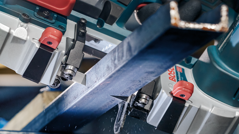 在工業環境中，金屬梁被電鋸精確切割。