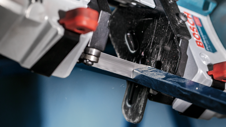 帶鋸在近距離工業環境中切割金屬棒。.