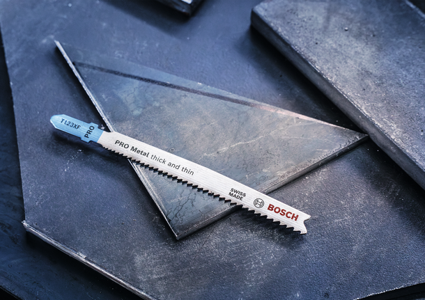 PRO Metal thick and thin T123XF 線鋸片,100 mm,5 件 金屬拼圖刀片放在深色金屬板上。