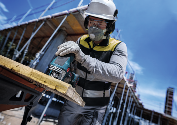 PRO Multi Material 厚薄通用款 T345XF 線鋸片,132 mm,5 件 在建築工地上,配戴安全設備的人員用曲線鋸切割木材。