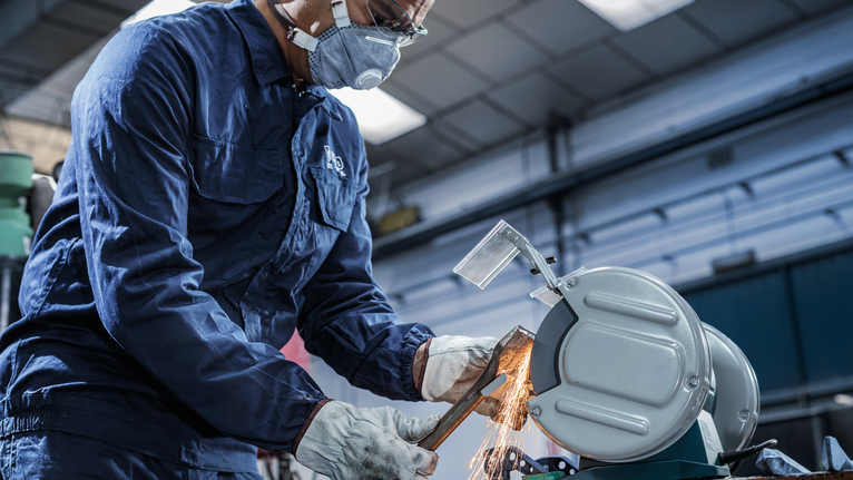 PRO Metal 研磨輪,200 x 25 x 32 mm,G36 配戴安全設備的人員使用金屬切割鋸切割管道,產生火花。