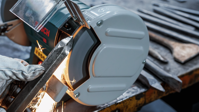 PRO Metal 研磨輪,200 x 25 x 32 mm,G36 配戴安全設備的人在台式砂輪機上打磨金屬,火花四濺。