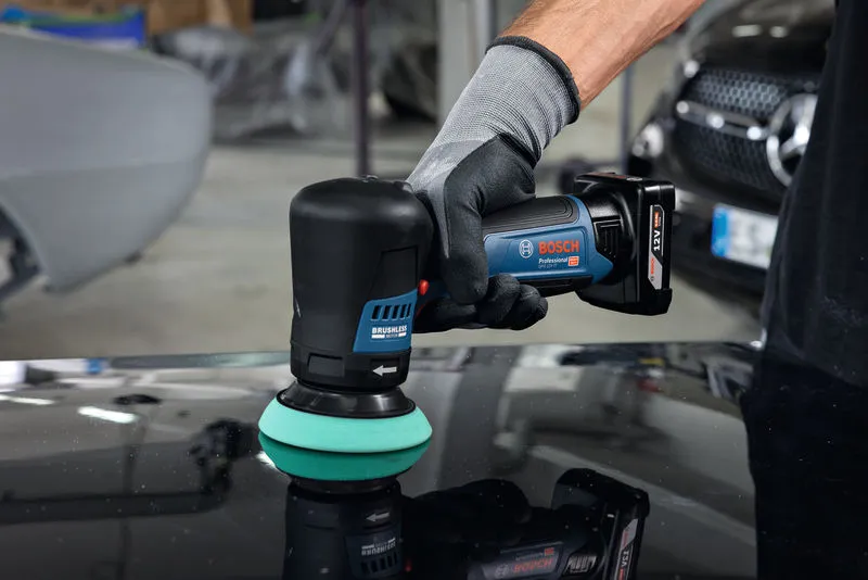 一名配戴安全設備的人員正在使用無線拋光機拋光汽車錶面。.