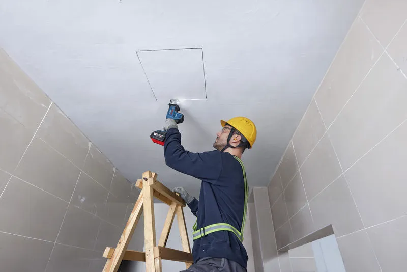 GSA 18V-24 一名配戴安全設備的人員使用往復鋸切割天花板。.