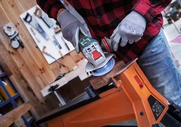 Object #200557592: 7425288_APP_WIDE_5 配戴安全設備的人員使用角磨機打磨夾在工作台上的木材。.