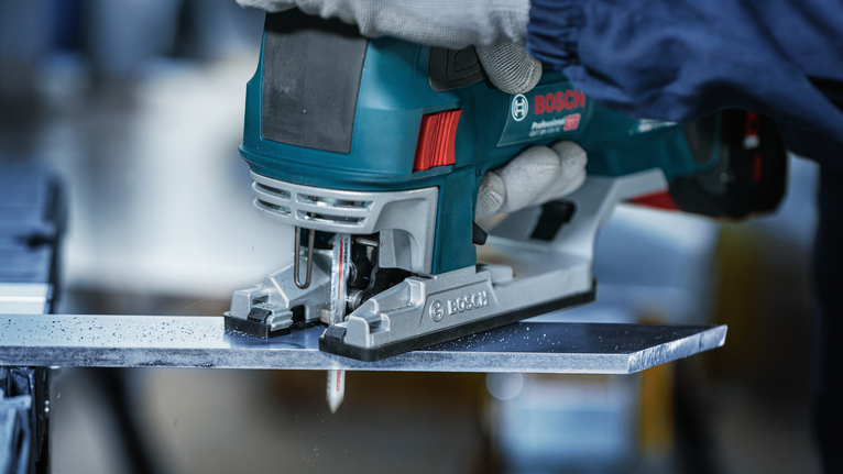 超耐久超厚金屬專業款 T155HHM 線鋸片,3 件 配戴安全設備的人員使用手持曲線鋸切割金屬板。