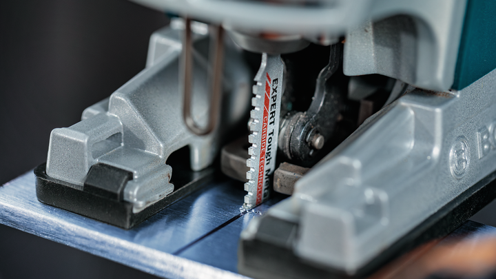 Object #200559115: 7478951_app_web_05 拼圖鋸刀片切割金屬板的特寫。