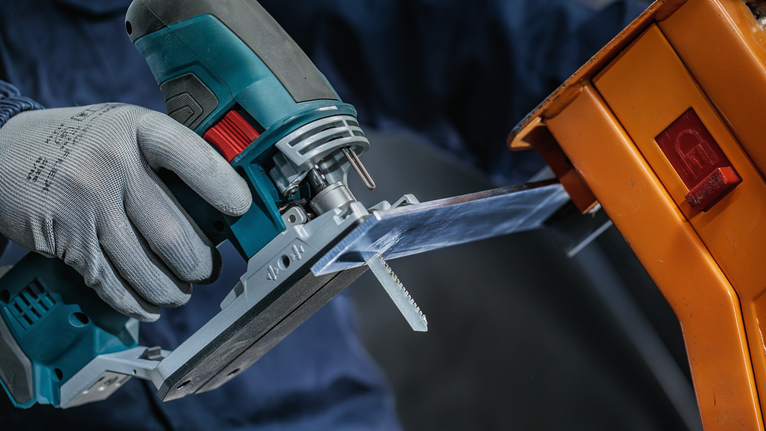 超耐久超厚金屬專業款 T155HHM 線鋸片,3 件 一名佩戴安全設備的人使用曲線鋸切割透明塑膠片。