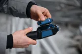 一個人將電池插入材料水分計。.