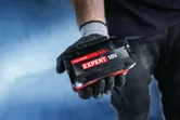 戴著手套的手中拿著Bosch專家 18V 電池組。.