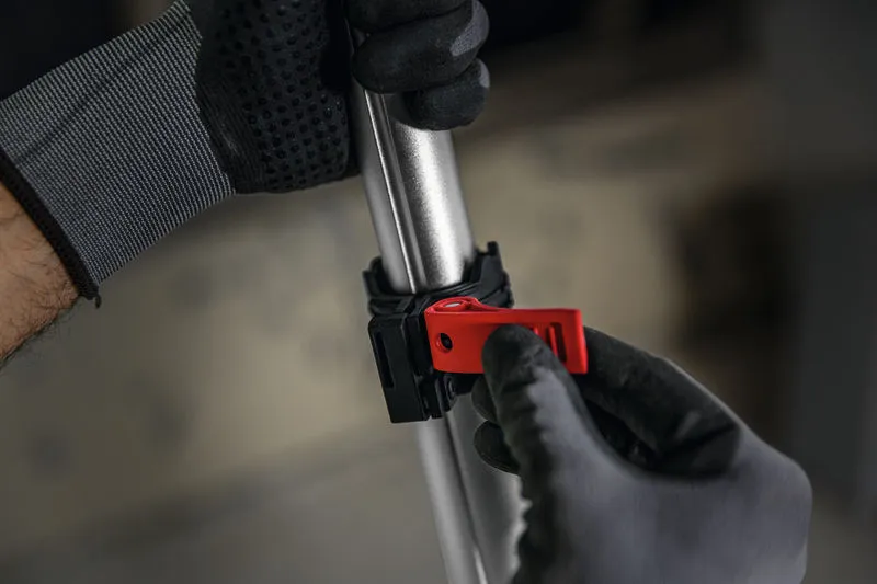 一名穿戴安全裝備的人員正在調整金屬桿上的紅色夾子。