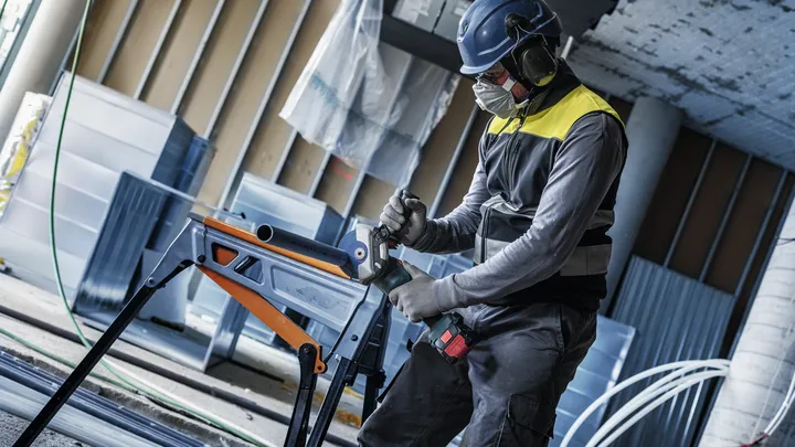 配戴安全設備的人員在工作台上鑽入金屬管。